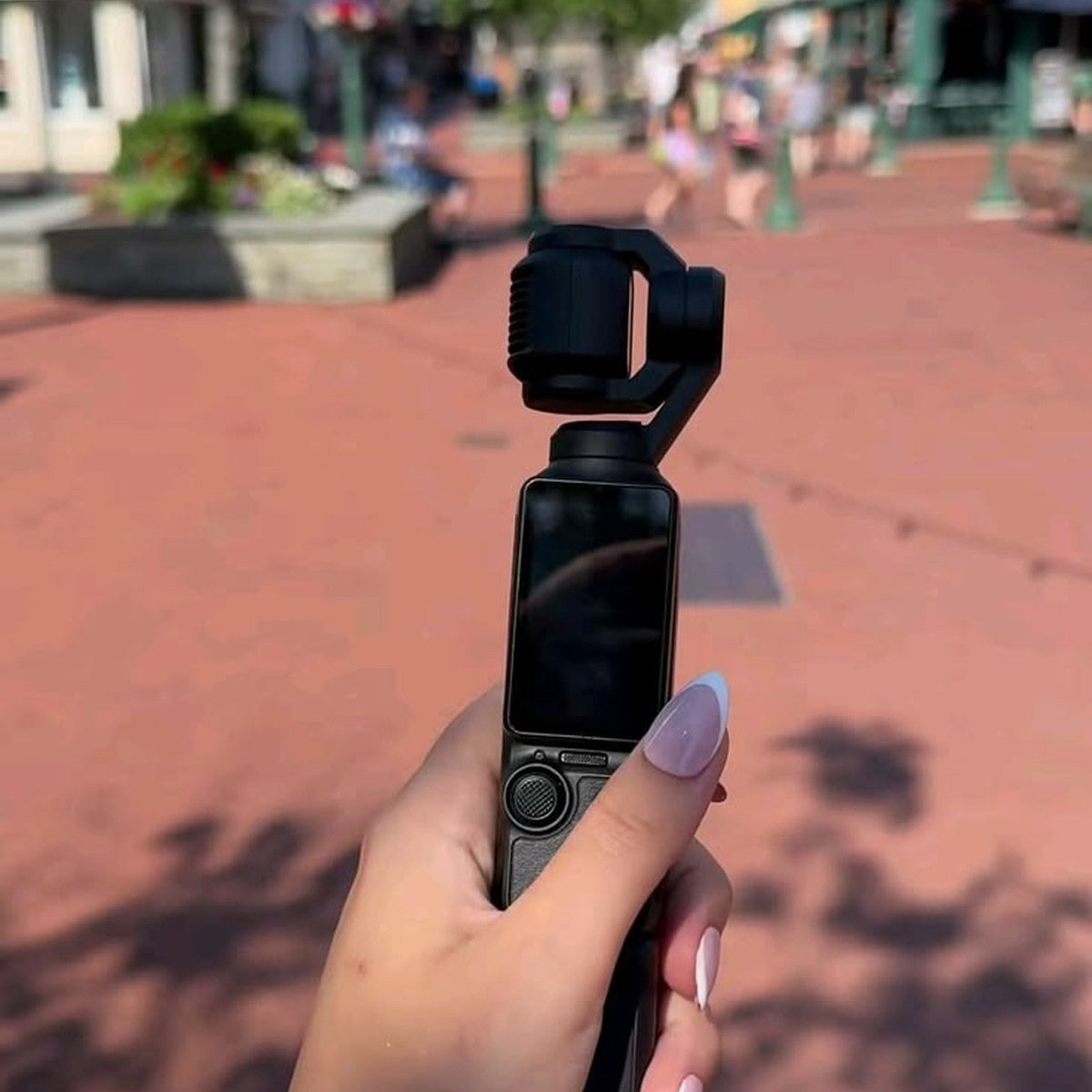 Caméra de poche tenue à la main en marchant dans la rue